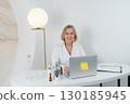 A Professional Woman Surrounded by Skincare Products Inside a Contemporary Modern Workspace 130185945