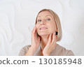 Senior woman sitting in front of mirror at home 130185948
