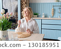 Healthy Lifestyle A Woman Delightfully Enjoying her life a Modern and Stylish Kitchen Space 130185951