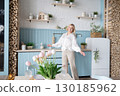Healthy Lifestyle A Woman Delightfully Enjoying her life a Modern and Stylish Kitchen Space 130185962