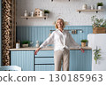 Healthy Lifestyle A Woman Delightfully Enjoying her life a Modern and Stylish Kitchen Space 130185963