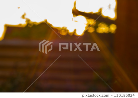 Abstract background with blurred ribbed tin wall, behind bright sun has flooded sky and sun's rays are pouring out from edges. A symbol that if you can cross this border, you will move to the light. 130186024