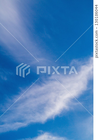 Landscape. A background of blue sky with blurred particles of clouds or other components in the upper atmosphere flowing in the wind. Displacement, the passage of time, abstract manifestations 130186044