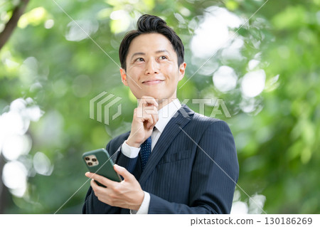 Business man, fresh greenery, smartphone 130186269