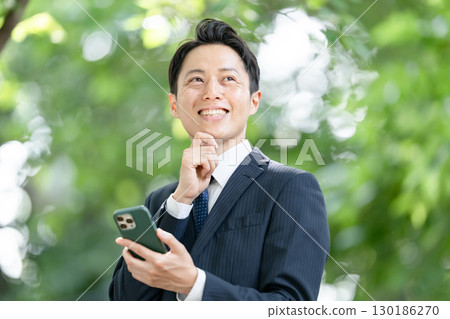 Business man, fresh greenery, smartphone 130186270