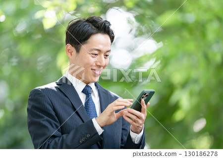 Business man, fresh greenery, smartphone 130186278