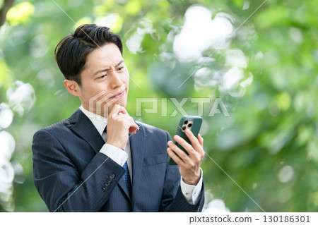 Business man, fresh greenery, smartphone, trouble 130186301