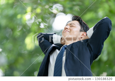 Business man stretching with fresh greenery Business man stretching with fresh greenery 130186320