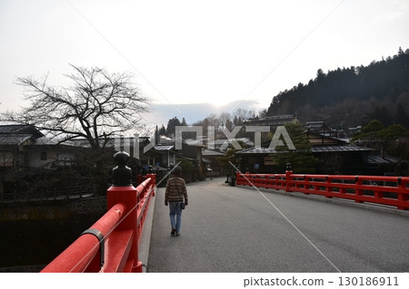 Gifu Prefecture, Japan: During the Takayama Festival in spring, tourists strolling along the tourist attraction Nakabashi Bridge, a beautiful sunrise and the surrounding cityscape 130186911