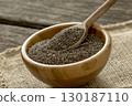 Spoon in round wooden bowl with chia seeds 130187110