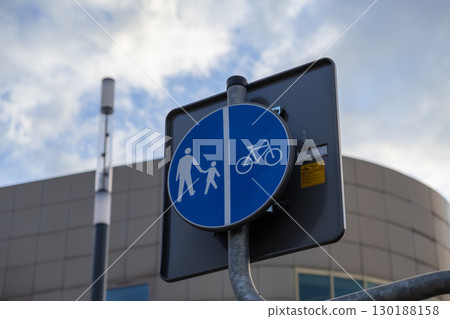 Blue circular road sign designating a combined pedestrian and bicycle path, promoting safety, urban mobility, and eco-friendly city transportation 130188158