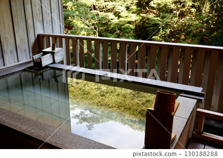 A quiet open-air bath surrounded by forest and a hot spring landscape with the warmth of wood 130188288