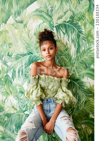 A woman is posing for a photo in front of a green wall A woman is posing for a photo in front of a green wall 130188334