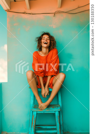 A woman in a red dress is sitting on a blue stool 130188350