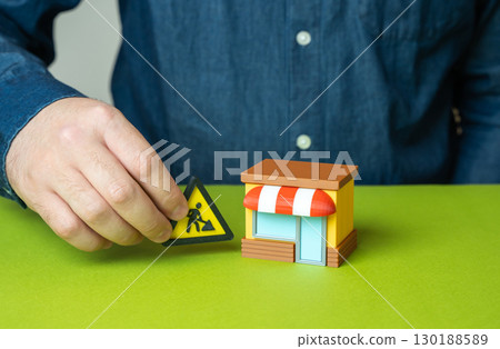 Man closes shop for repairs. Urgent work to eliminate problems in business, temporary closure, renovation, business maintenance, fixing breakdowns, restoring activity 130188589