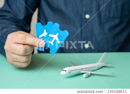 Man with tickets and passenger plane. Book and buy tickets for the flight. Setting off on a journey, air travel planning, holiday trip, vacation booking 130188611