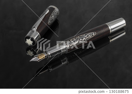 Fountain pen on dark marble background. Rare writing instruments. Fountain pen on dark marble background. Rare writing instruments. 130188675