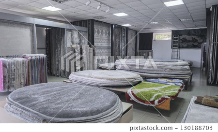 Carpets and rugs lie on the counters and hang on the stands for sale Carpet shop Carpets and rugs lie on the counters and hang on the stands for sale Carpet shop 130188703