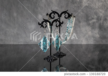 Bracelet and earrings made of beads on a light background. Handmade. Jewelry Bracelet and earrings made of beads on a light background. Handmade. Jewelry 130188720