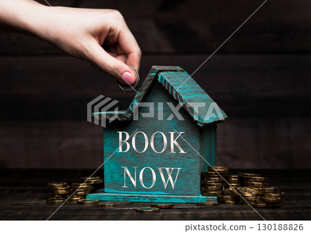 Wooden house model with coins next to it and hand Wooden house model with coins next to it and hand 130188826
