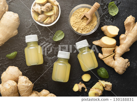 Bottles of immune ginger energy shot drink with ginger root and grounded powder on black.Macro. 130188831