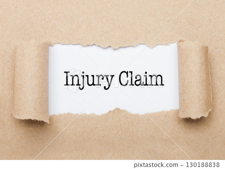 Injury Claim text appearing behind brown paper Injury Claim text appearing behind brown paper 130188838
