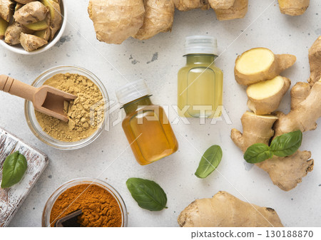 Bottles of immune turmeric ginger energy shot drink with fresh raw ginger roots and oranges fruits. 130188870