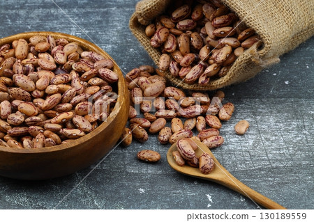 red kidney beans in wooden bowl isolated on dark background. red kidney beans in wooden bowl isolated on dark background. 130189559