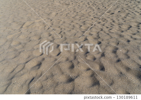 Wind-etched patterns in the beach sand Wind-etched patterns in the beach sand 130189611