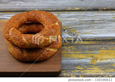 Turkish traditional bagel / simit with sesame on rustic table, turkish breakfast pastry concept 130190011