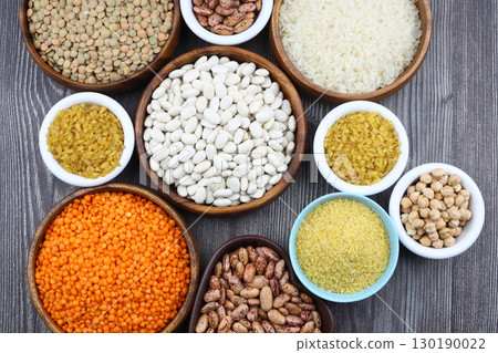 Different type of raw dry legumes composition. White Rice, lentils, red lentils, chickpeas and kidney beans. Mix organic legume concept. Different type of raw dry legumes composition. White Rice, lentils, red lentils, chickpeas and kidney beans. Mix organic legume concept. 130190022