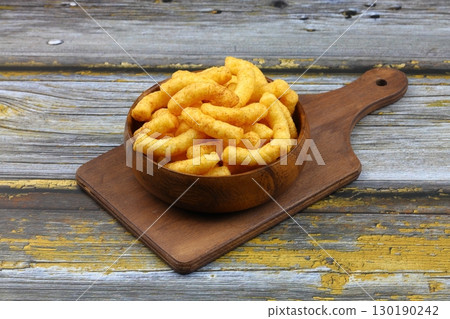 Puffed corn peanuts snacks isolated on wooden background. Puffed corn peanuts snacks isolated on wooden background. 130190242