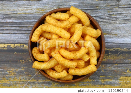 Puffed corn peanuts snacks isolated on wooden background. Puffed corn peanuts snacks isolated on wooden background. 130190244