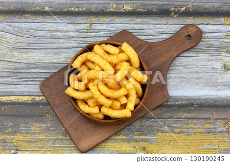 Puffed corn peanuts snacks isolated on wooden background. 130190245