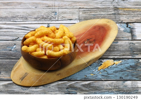 Puffed corn peanuts snacks isolated on wooden background. Puffed corn peanuts snacks isolated on wooden background. 130190249