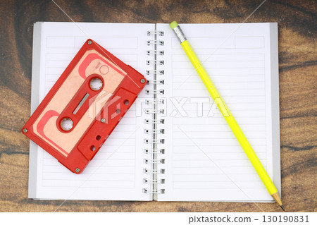 Retro audio cassette tape from the 80s and 90s on a white background. blank playlist on notebook. Top view, nostalgic concept. 130190831