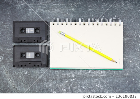 Retro audio cassette tape from the 80s and 90s on a white background. blank playlist on notebook. Top view, nostalgic concept. Retro audio cassette tape from the 80s and 90s on a white background. blank playlist on notebook. Top view, nostalgic concept. 130190832