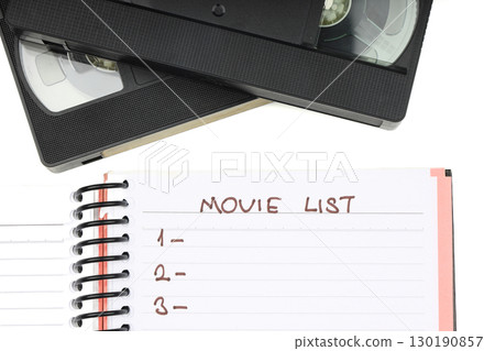 Black VHS video tape cassette with blank label isolated on white background. And empty movie list. 130190857