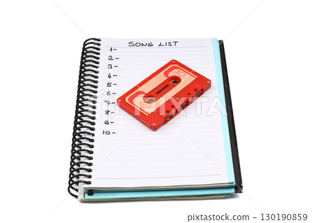 Retro audio cassette tape from the 80s and 90s on a white background. blank playlist on notebook. Top view, nostalgic concept. 130190859