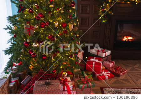 Classical Christmas decorated interior living room with fireplace. Christmas tree with red golden ornament decorations gift boxes. Modern classic style interior design apartment. Christmas eve at home 130190886
