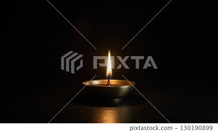 Minimalist Brass Diya Lighting Against Pure Black Background Symbolis. Dashahra, India. 130190899