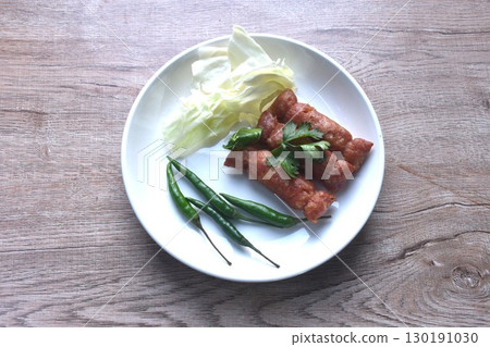 fried Thai north east sausage sfuffing fermenting chop pork and rice eat couple fresh cabbage with chili on plate 130191030