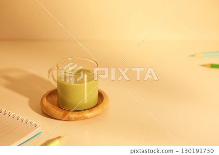 Matcha milk tea and notebook under warm sunlight 130191730