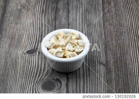 handmade manti (turkish ravioli type dumplings) on wooden   bowl, before cooking 130192026