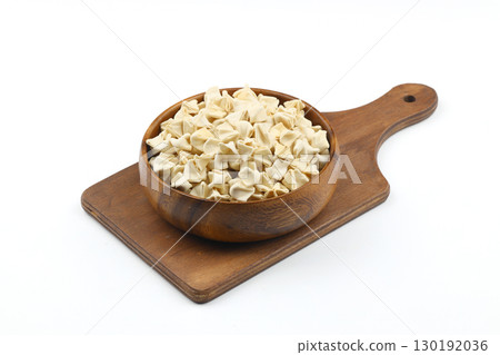 handmade manti (turkish ravioli type dumplings) on wooden bowl, before cooking. isolated on white background. handmade manti (turkish ravioli type dumplings) on wooden bowl, before cooking. isolated on white background. 130192036