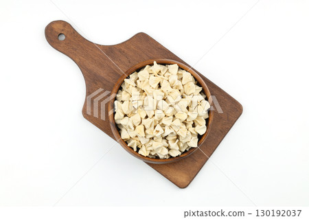 handmade manti (turkish ravioli type dumplings) on wooden bowl, before cooking. isolated on white background. 130192037