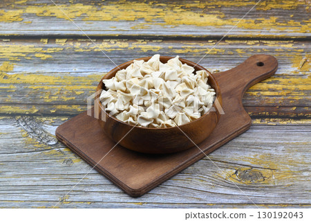 handmade manti (turkish ravioli type dumplings) on wooden   bowl, before cooking 130192043