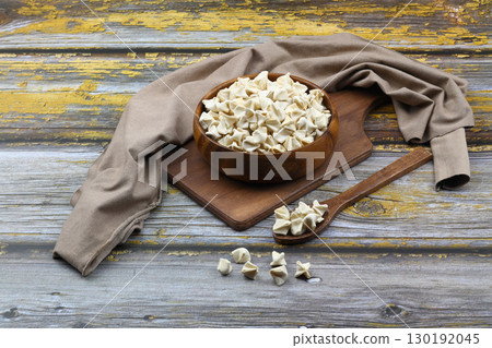 handmade manti (turkish ravioli type dumplings) on wooden bowl, before cooking handmade manti (turkish ravioli type dumplings) on wooden bowl, before cooking 130192045