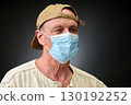 Closeup portrait of a elderly man in studio wearing a facial mask 130192252