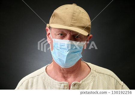 Closeup portrait of a elderly man in studio wearing a facial mask 130192256
